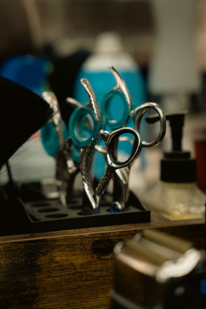 about-04 Close-up of professional hairdressing scissors in a salon environment, offering a glimpse into hairstyling tools.