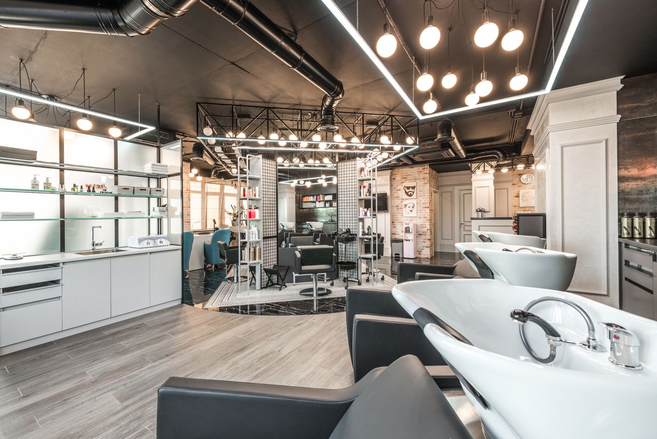 about-02 Backwash chairs with sinks placed in spacious modern beauty salon with stylish design and various cosmetology products with professional equipment